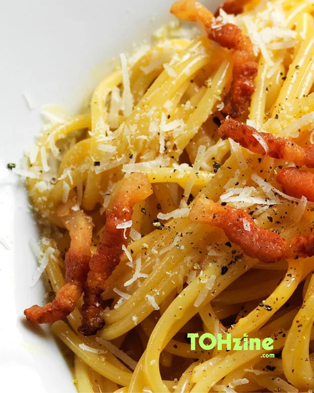 Piatto di spaghetti alla carbonara con guanciale croccante e pecorino romano grattugiato